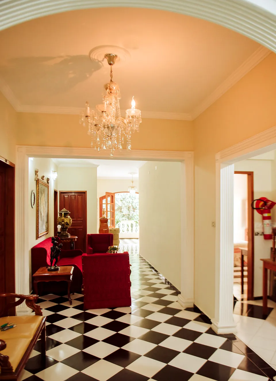 Corredor com lustre de cristal e piso xadrez preto e branco